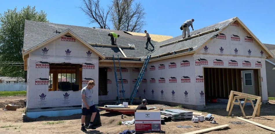 A man is standing in front of a house under construction.