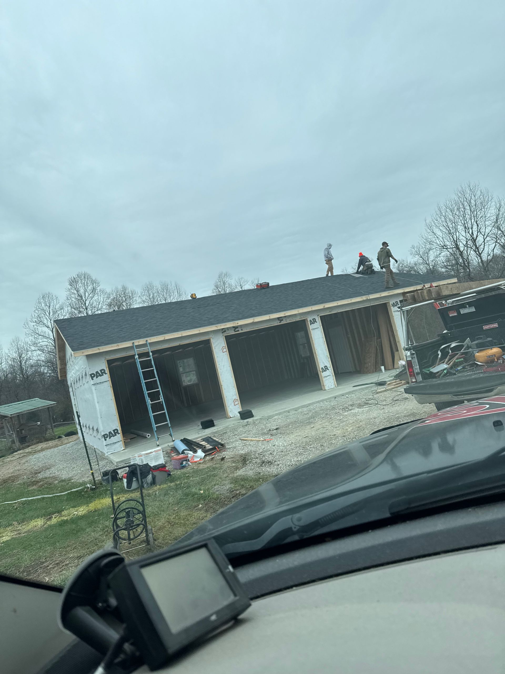 A group of people are working on the roof of a house.