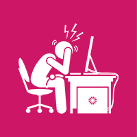 Um homem está sentado em uma mesa com a cabeça entre as mãos em frente a um computador.
