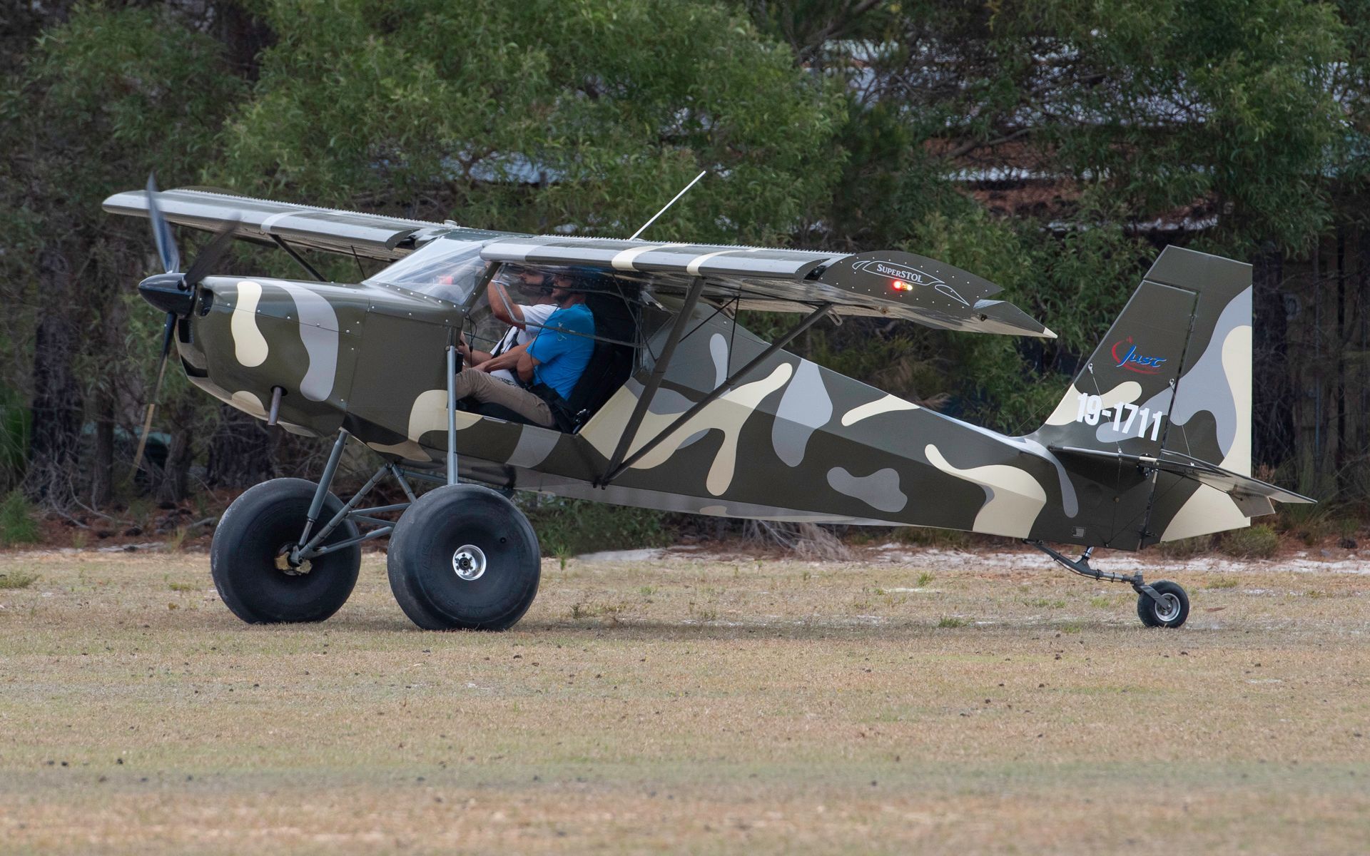 a man is sitting in a small plane on a runway .