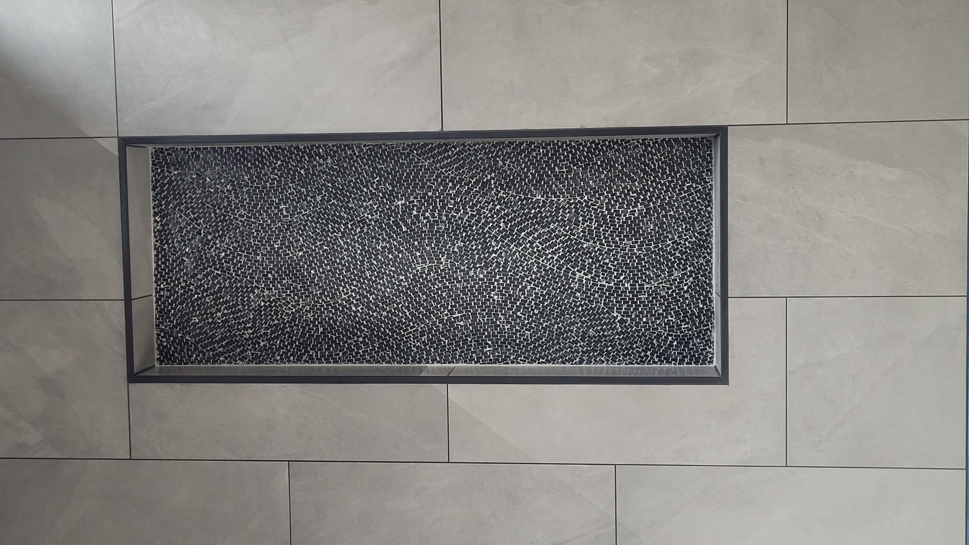 A black and white rug is sitting on a tiled floor.