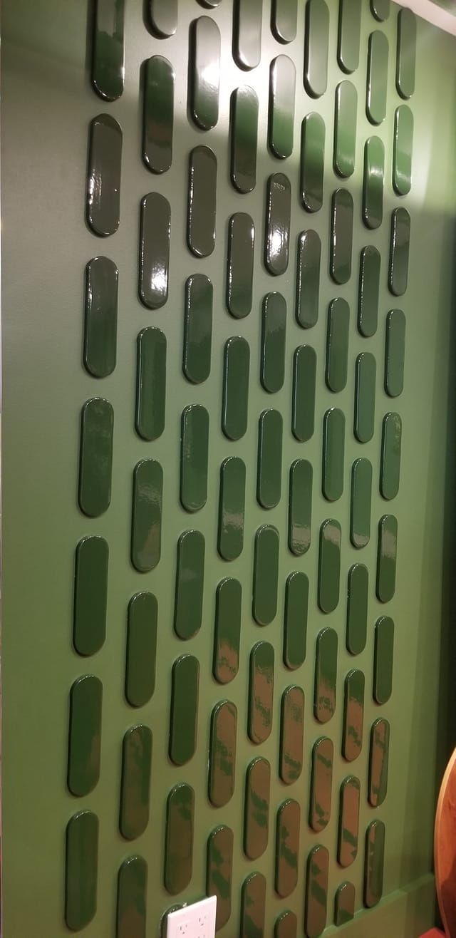 A green wall with a pattern of pills on it.