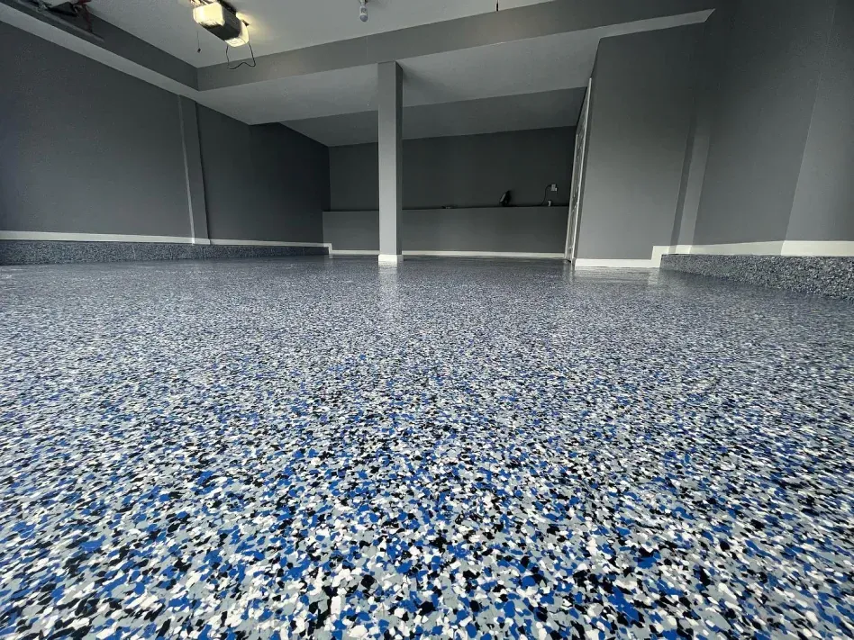 Empty room with blue-speckled epoxy floor and gray walls