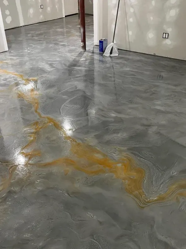 Gray concrete floor with a gold resin vein pattern in an unfinished room