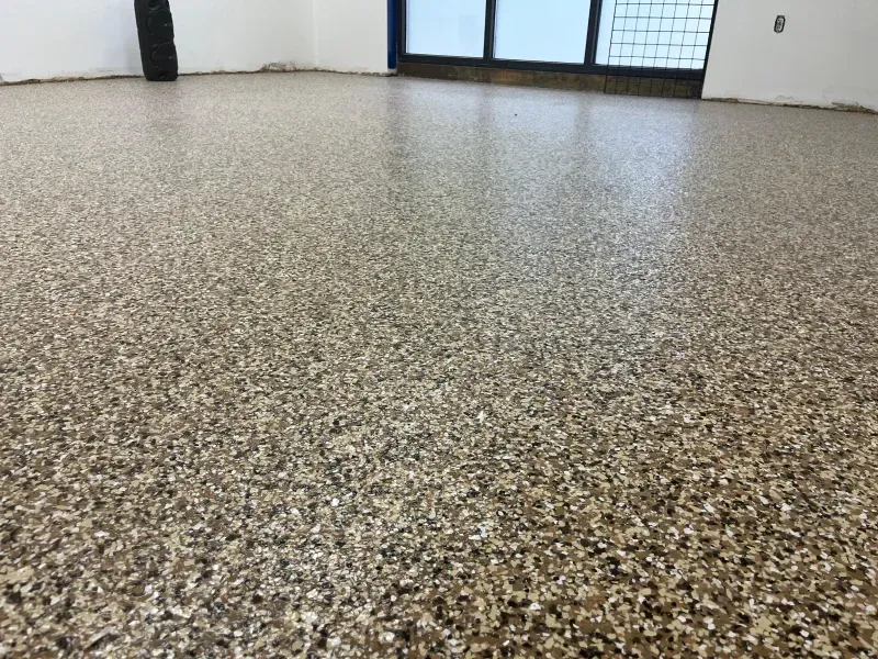 Speckled terrazzo floor in an empty room with white walls and doors