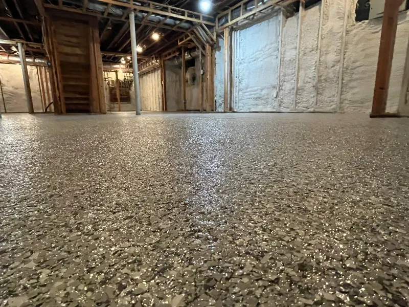 Empty warehouse interior with polished speckled concrete floor and exposed wooden framing