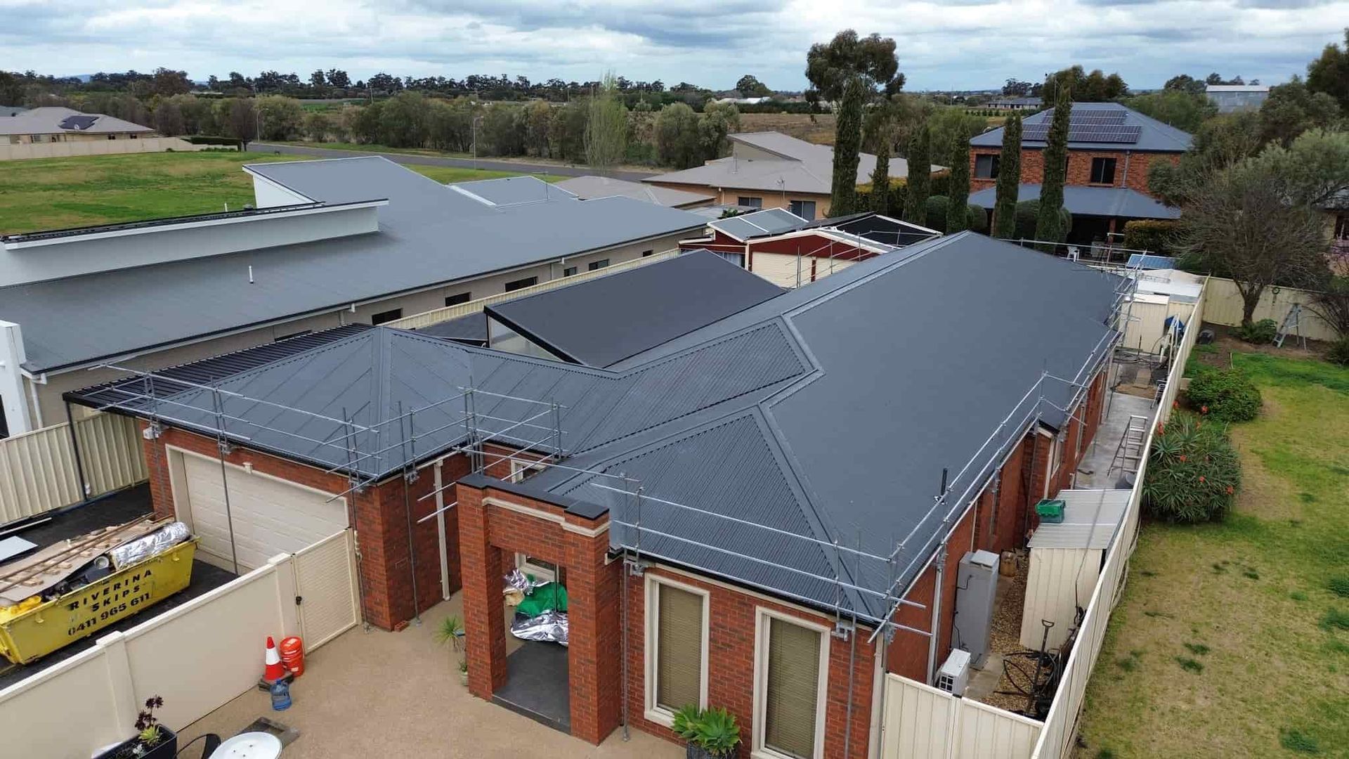 An Aerial View of a House With a Black Roof — Essential Roofing and Plumbing in Griffith, NSW