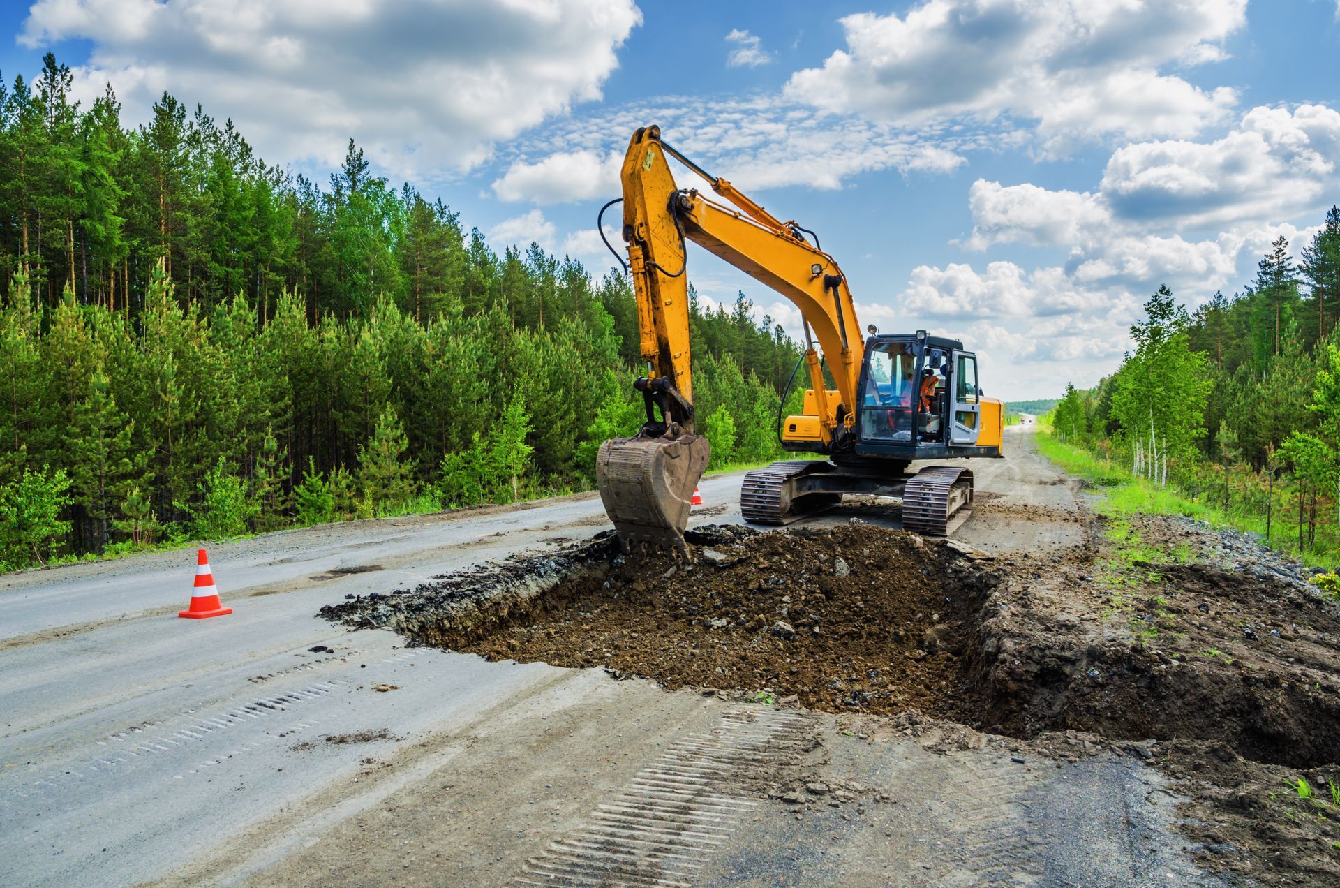 Destruction of the road surface on an intercity highway using an excavator to replace it