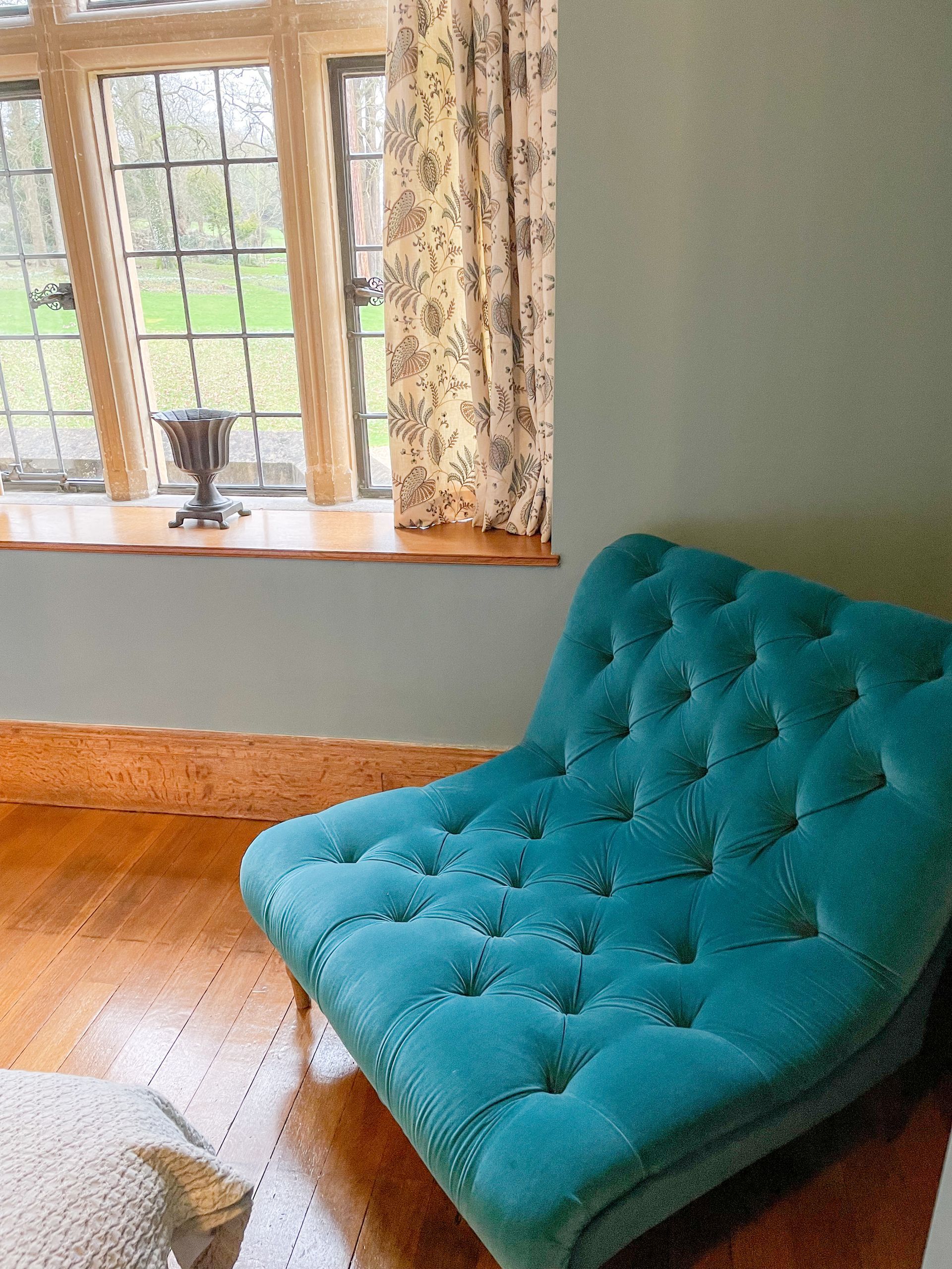 A blue chair is sitting in front of a window