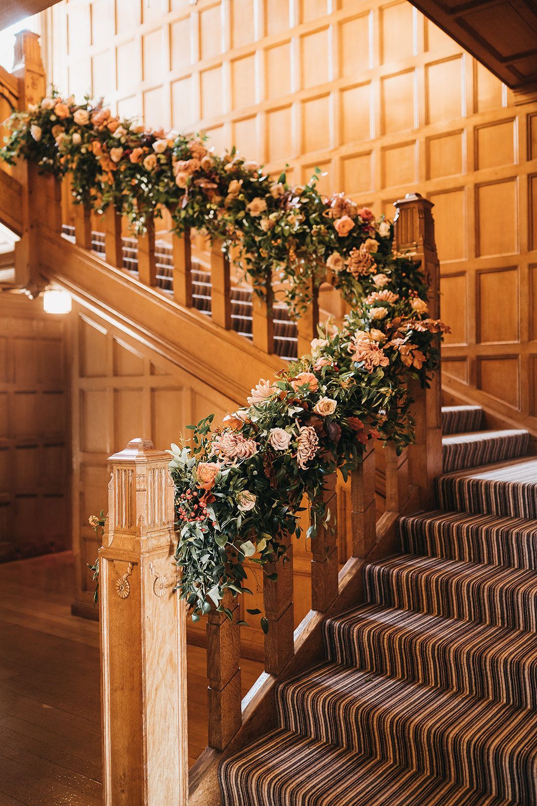 A wooden staircase decorated with flowers and greenery.