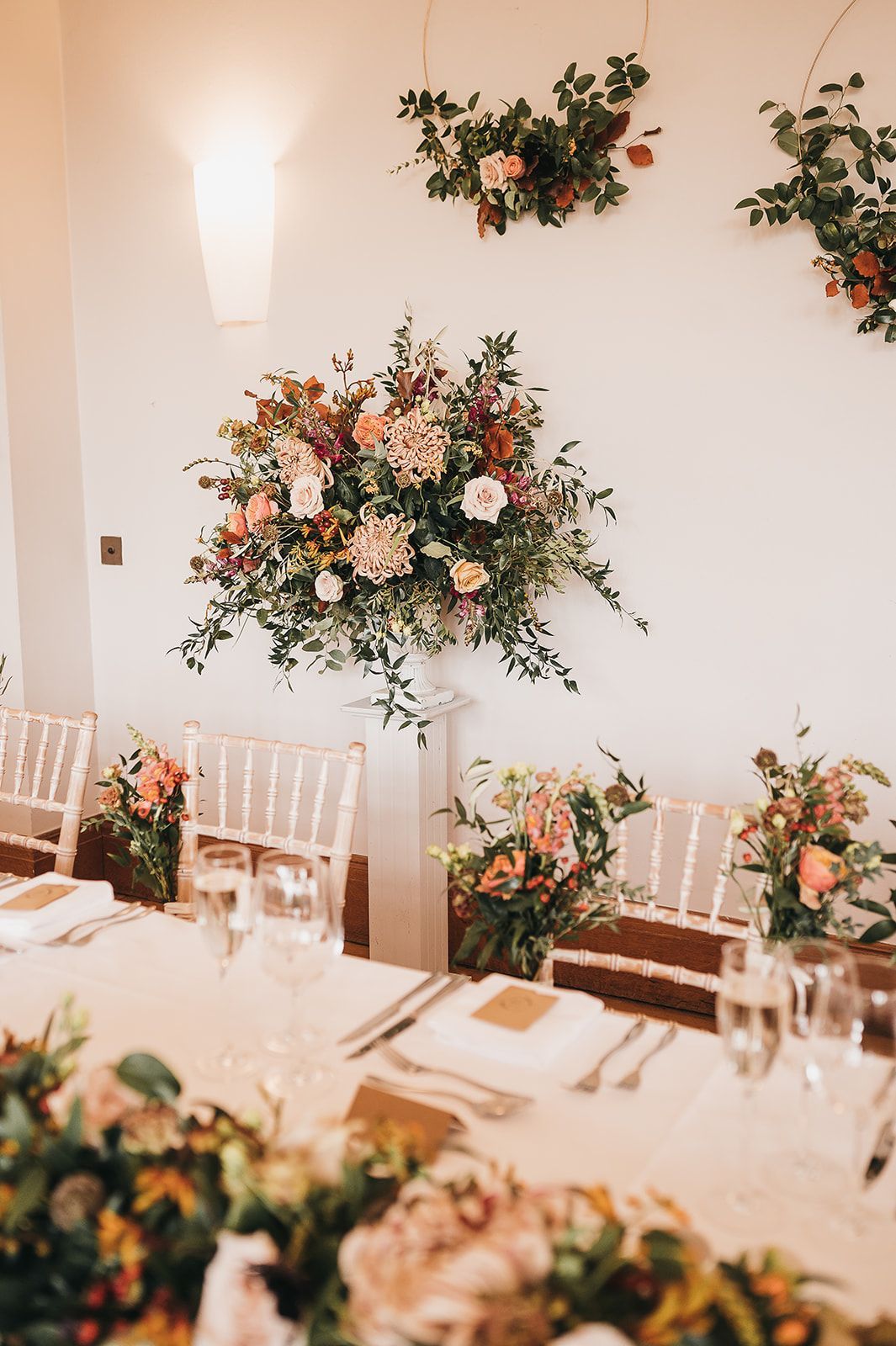 A room with a table and chairs and flowers on the wall.