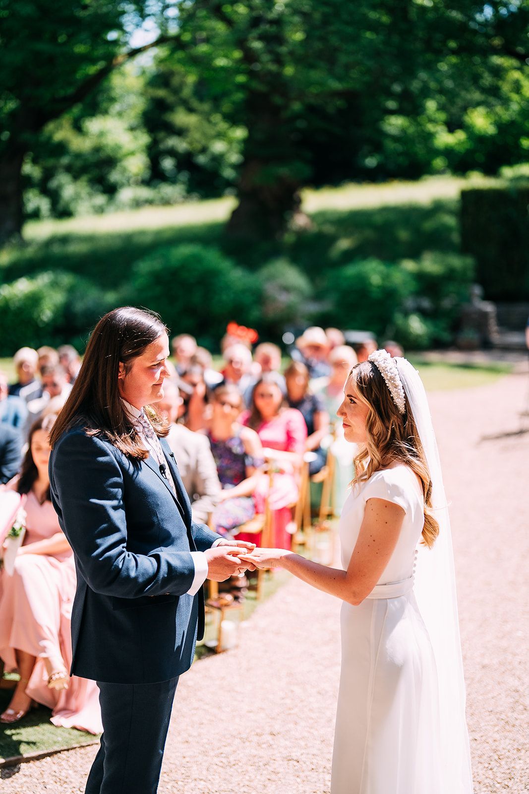 A bride and groom are exchanging rings during their wedding ceremony.