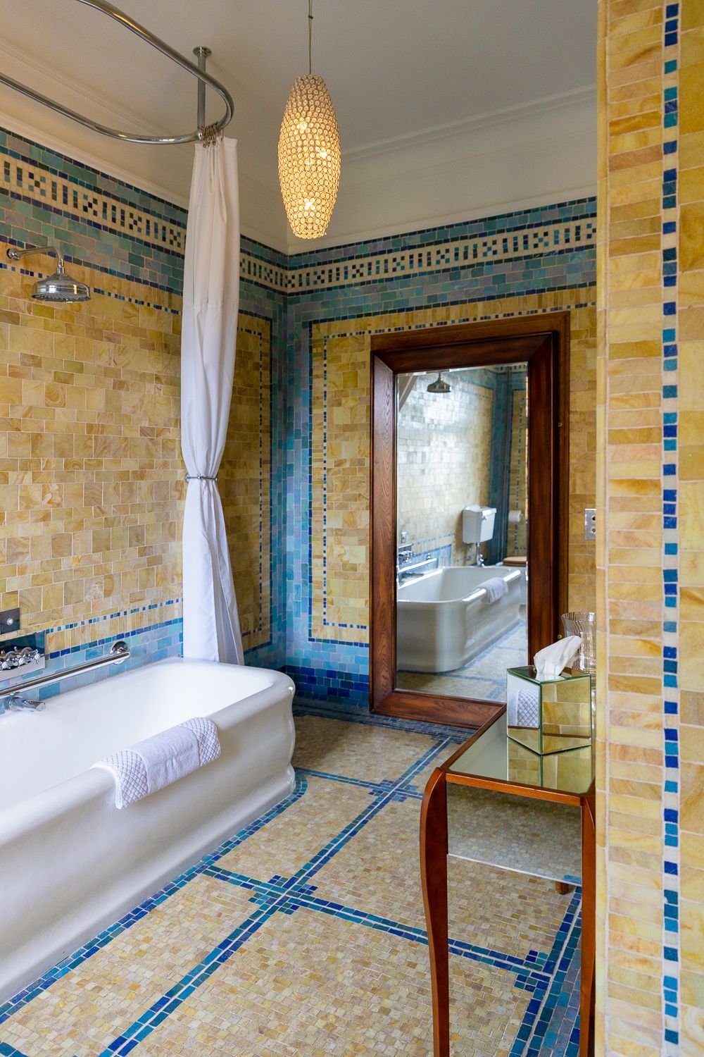 A bathroom with a bathtub , mirror and shower curtain.