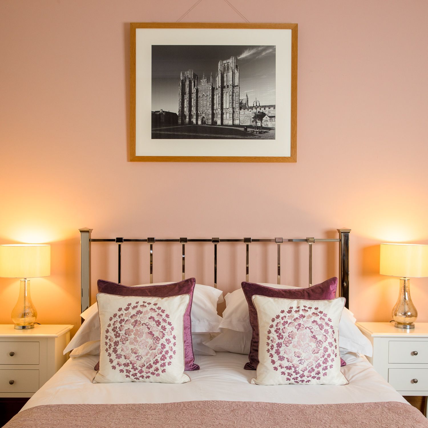 A bedroom with a picture on the wall above the bed