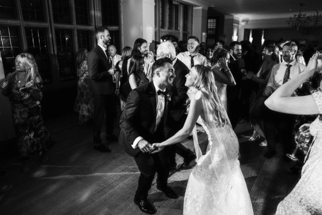 A black and white photo of a bride and groom dancing at a wedding reception.