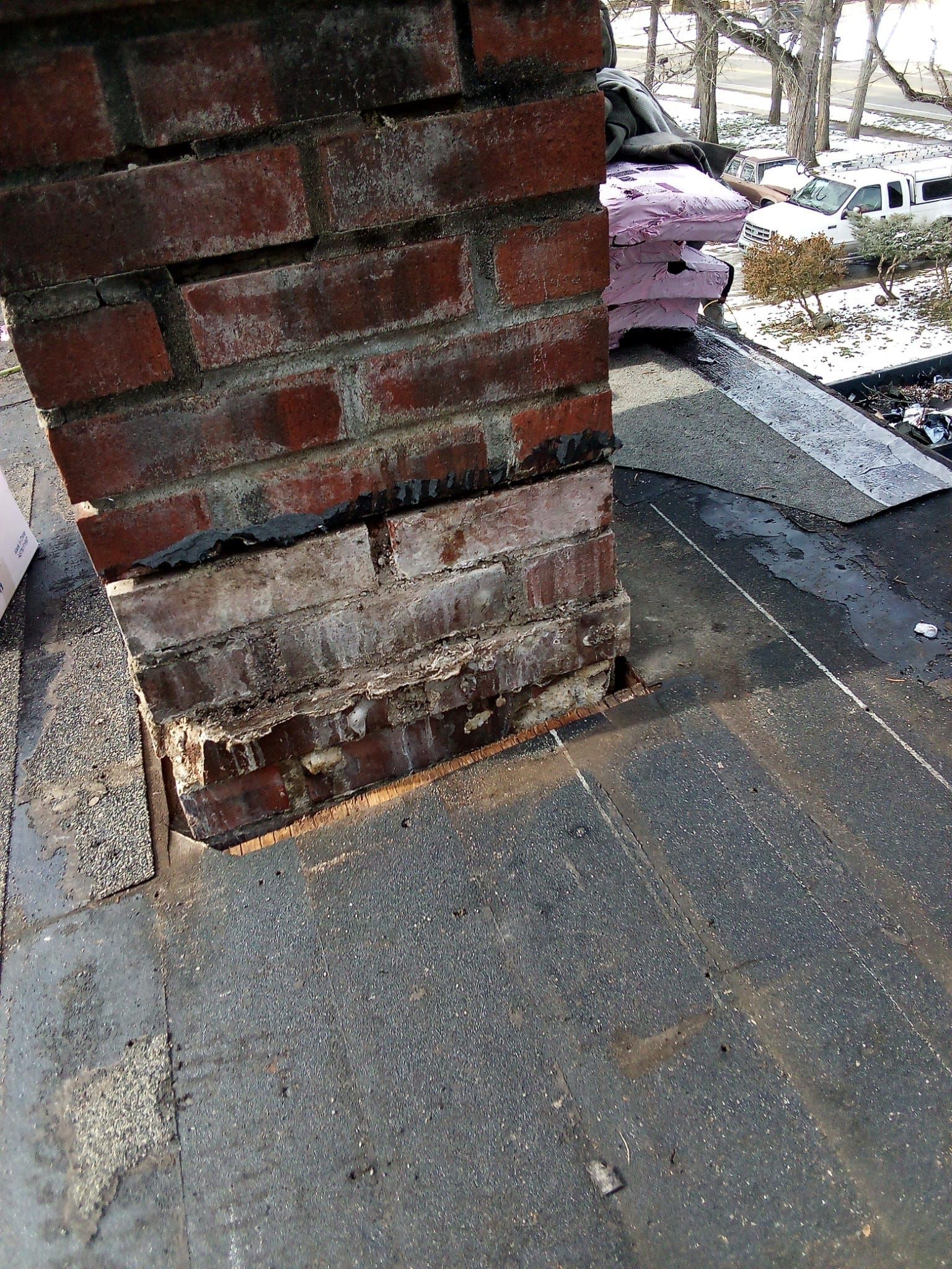 A brick chimney is sitting on top of a roof.