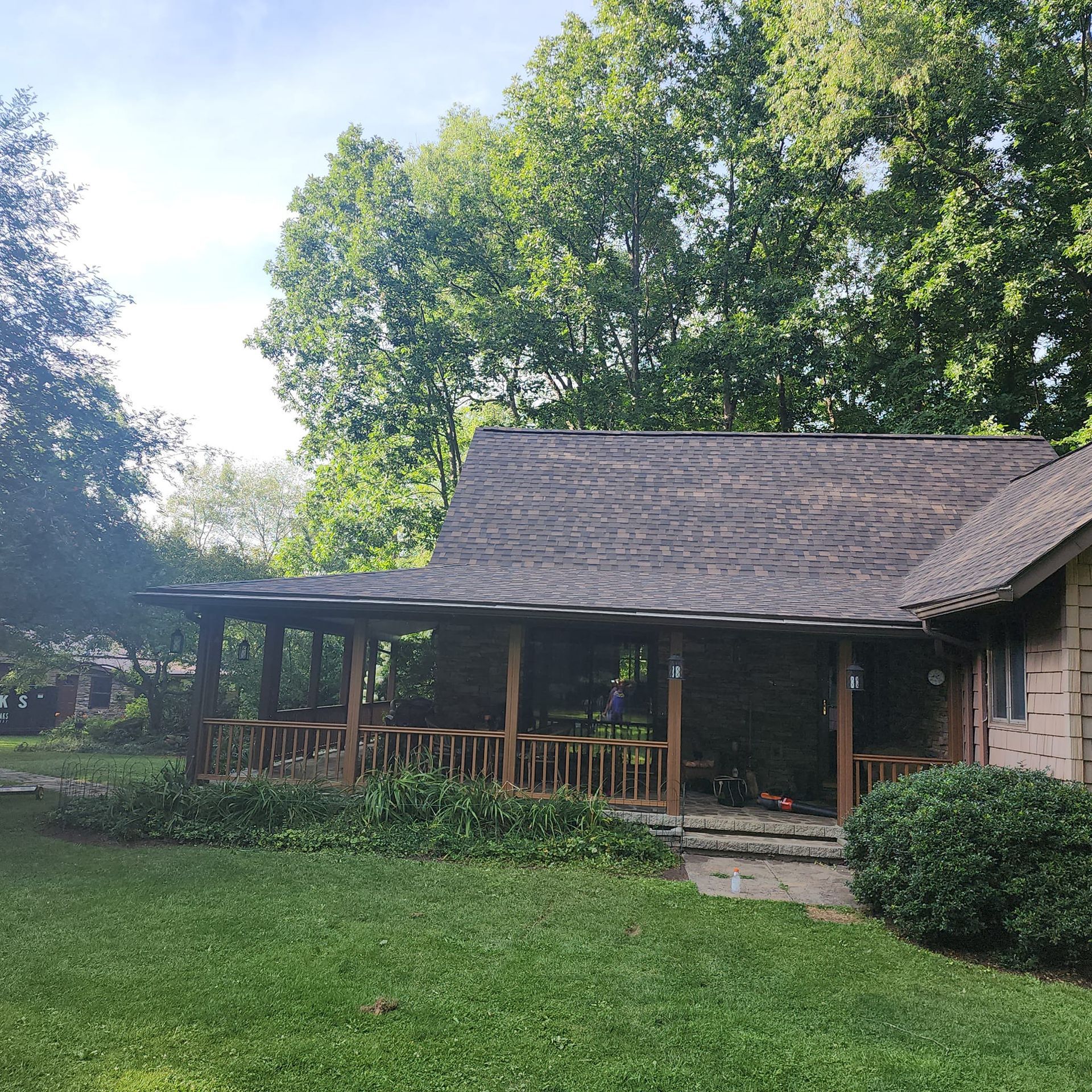 A house with a porch and trees in the background