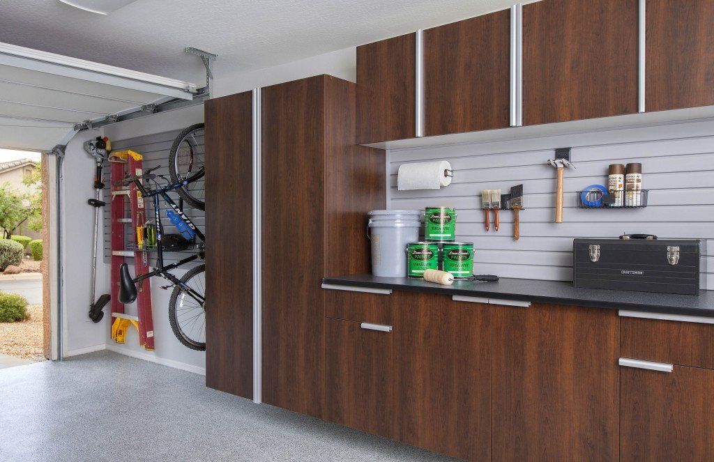 A garage with wooden cabinets and a ladder hanging on the wall.
