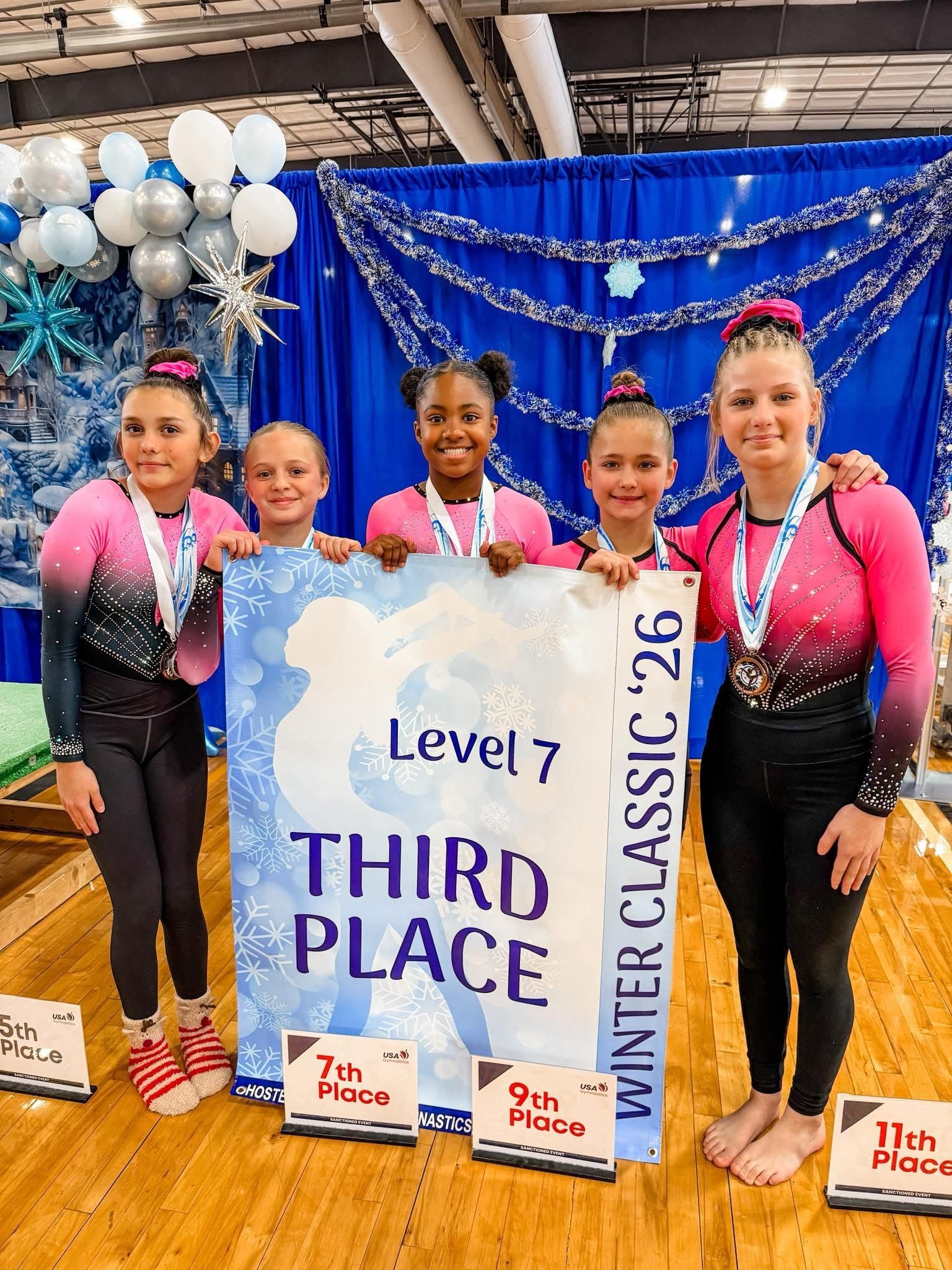 Gymnasts with medals, holding a 