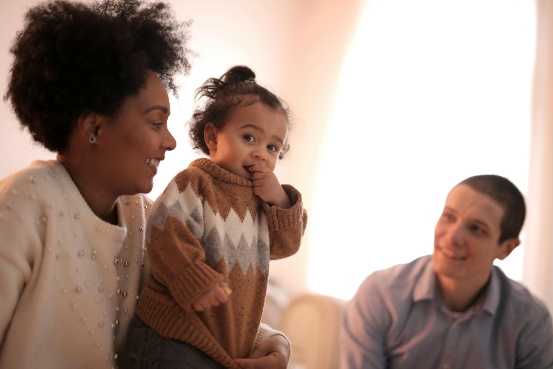 A family is sitting on a couch reading a book together.
