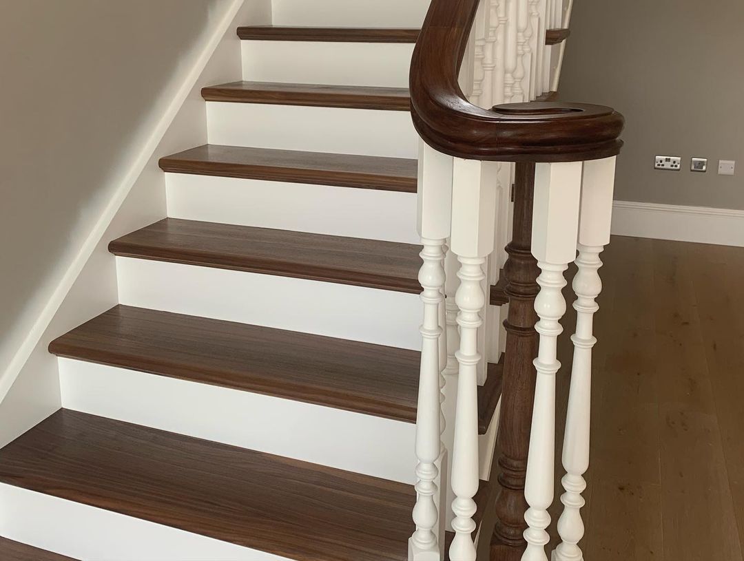 a wooden staircase with white steps and a wooden railing .