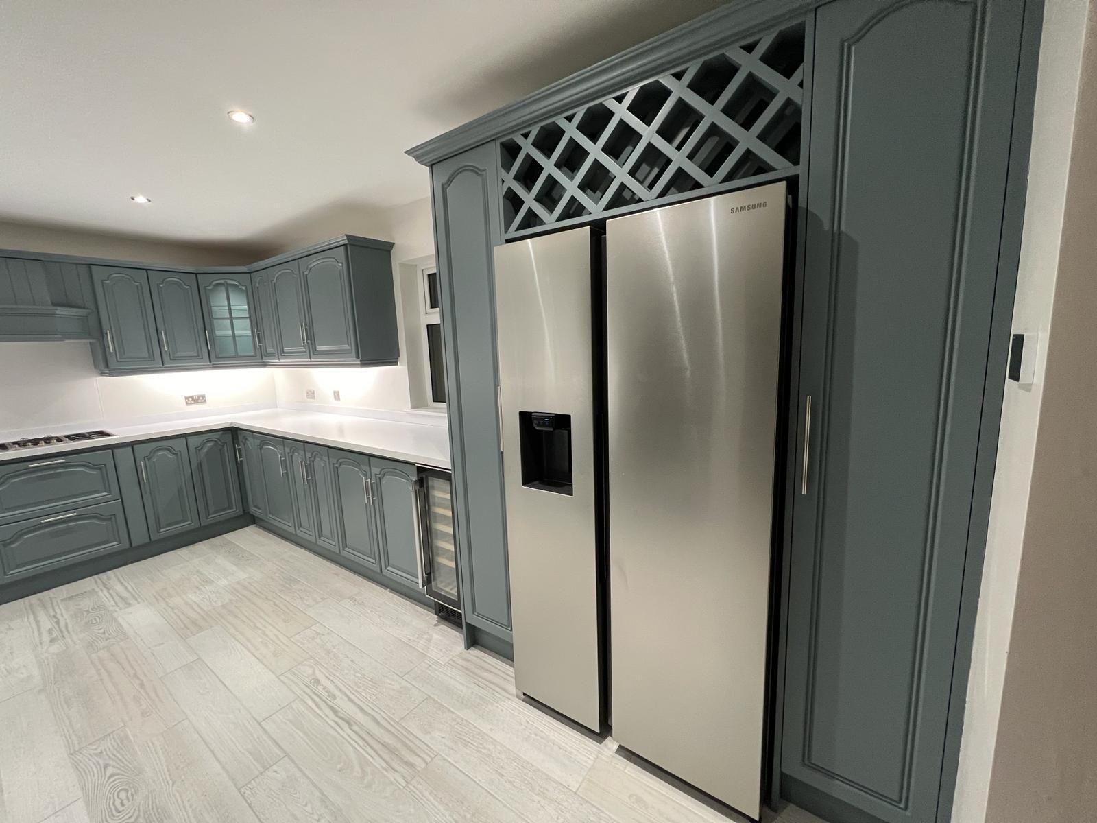 a kitchen with stainless steel appliances and gray cabinets .