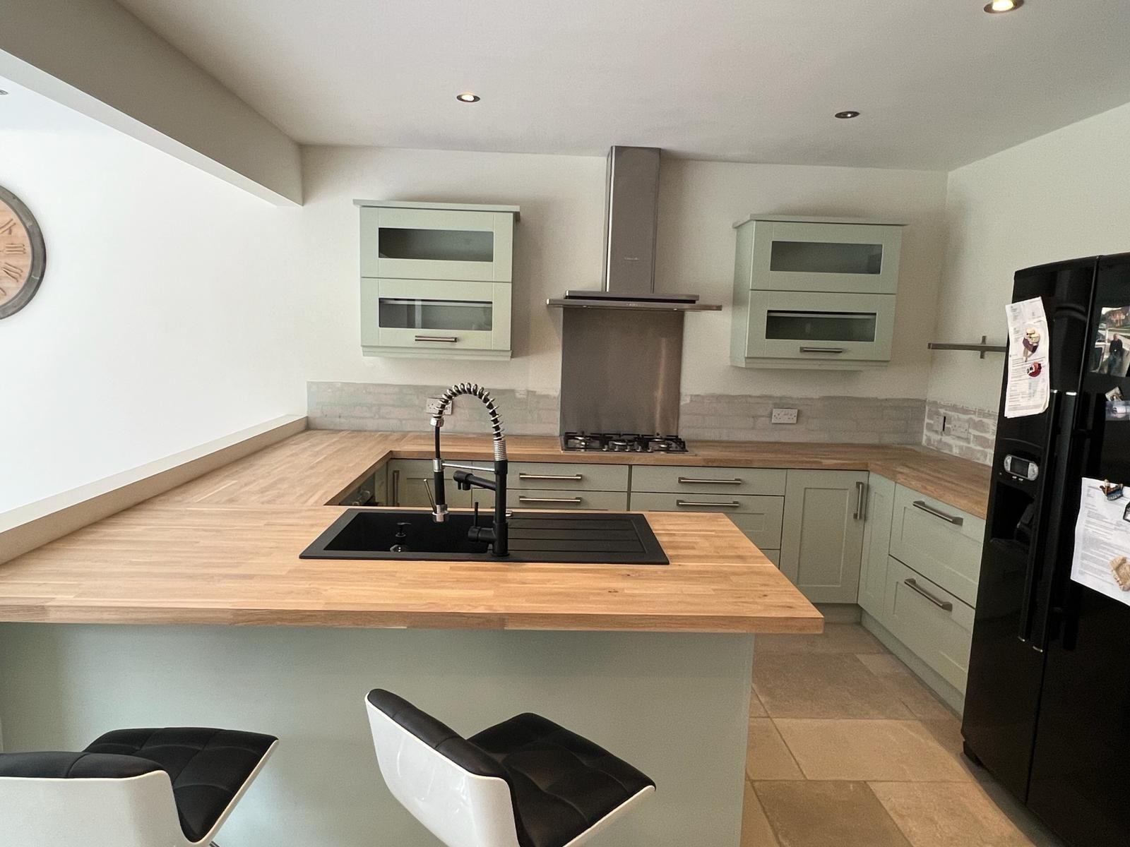 a kitchen with white cabinets and a black refrigerator