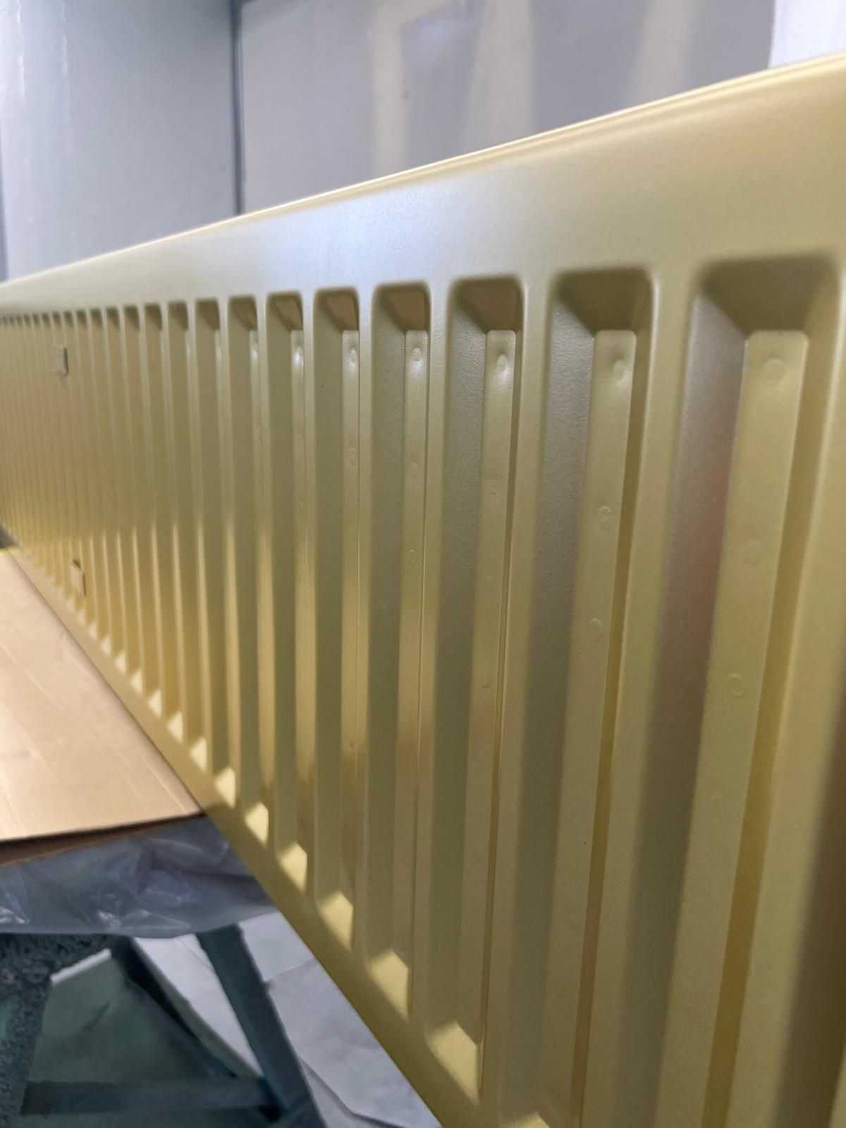 A close up of a yellow radiator in a room.