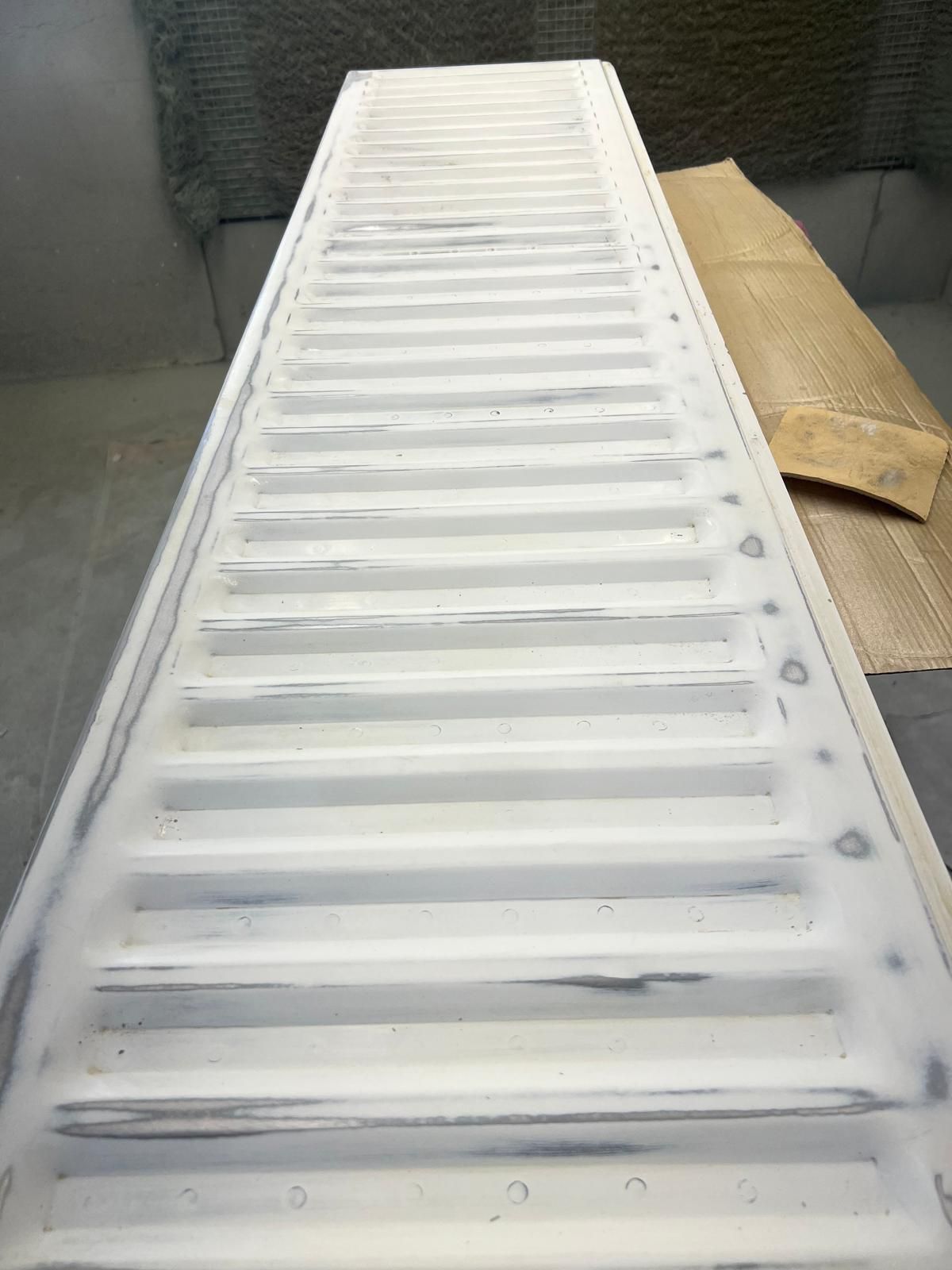 A white radiator is sitting on top of a cardboard box.