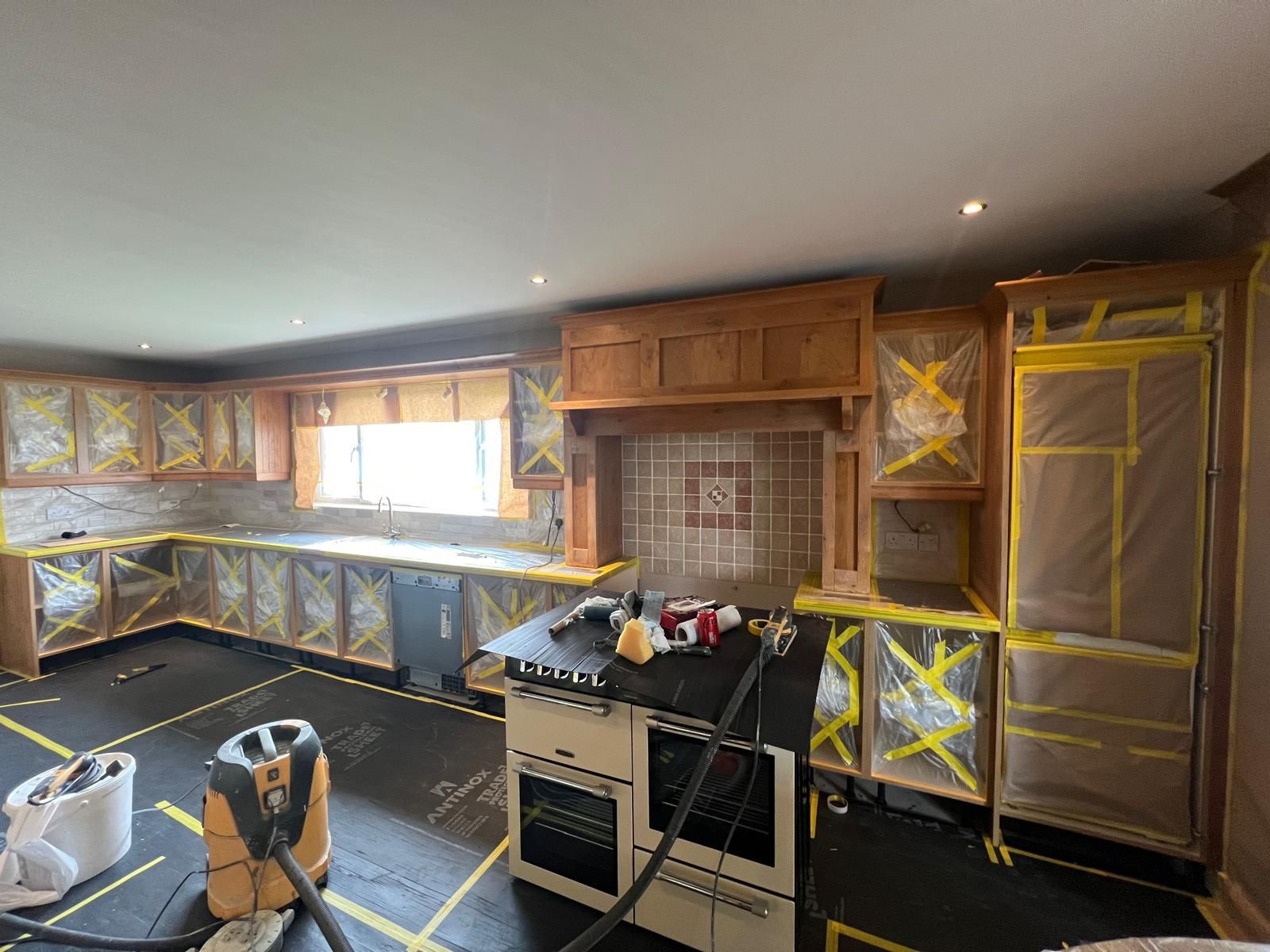 A kitchen is being remodeled with wooden cabinets and a stove.