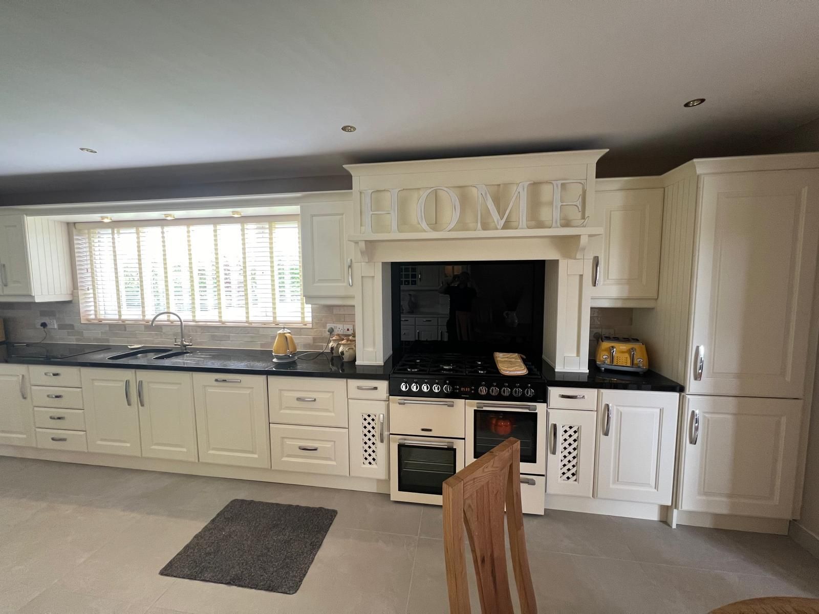 A kitchen with white cabinets and a stove top oven