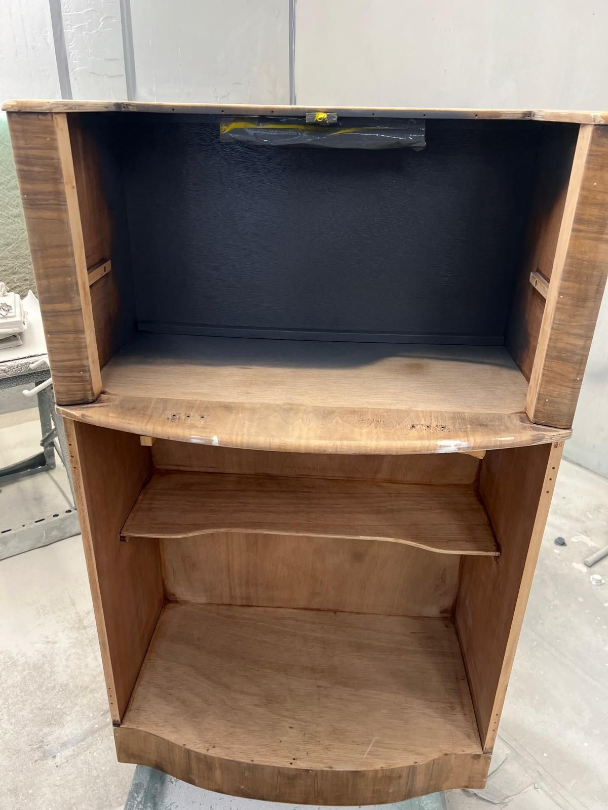 A wooden shelf with a black top is sitting on a table.