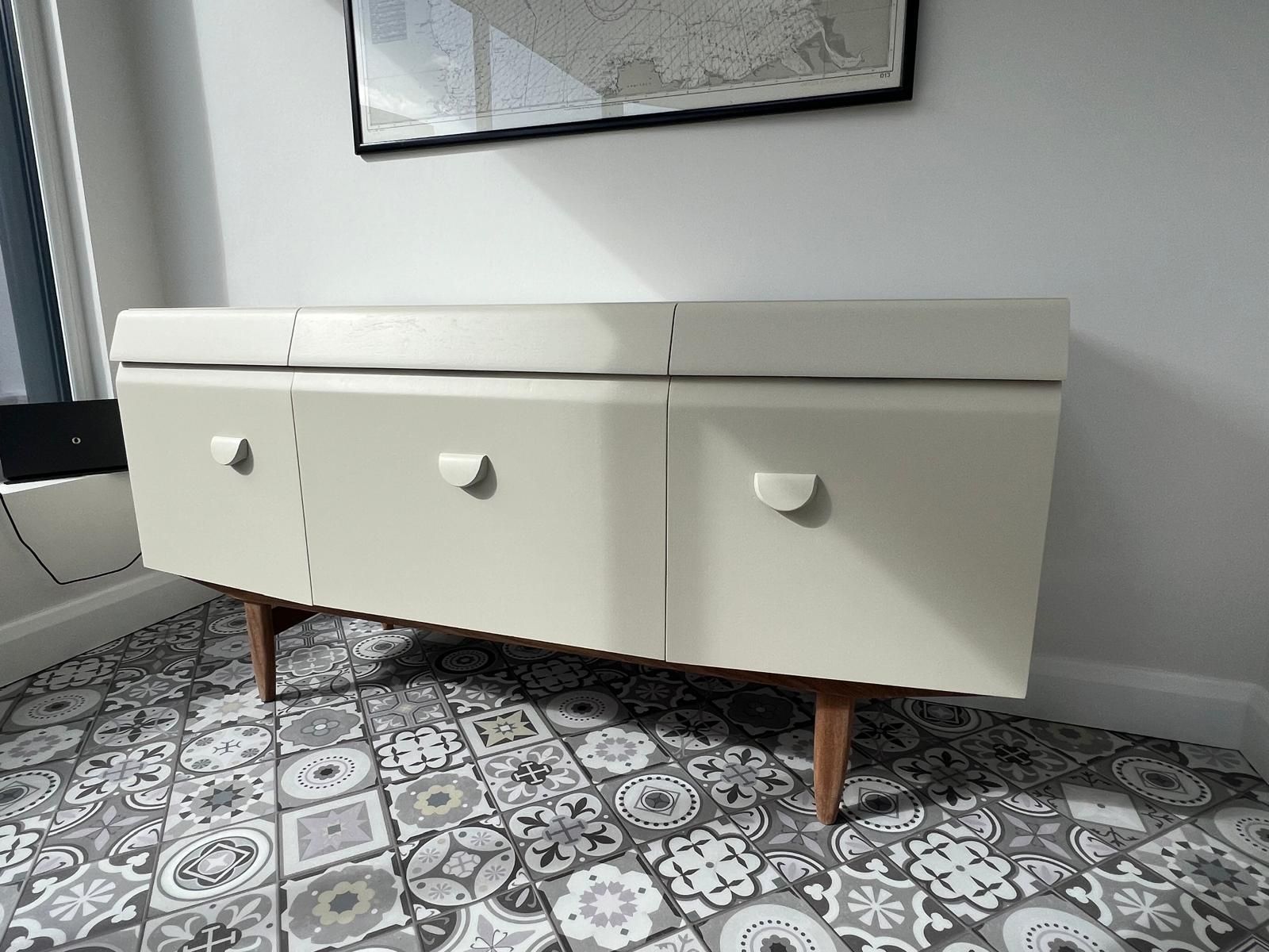 A white dresser is sitting on a tiled floor in a room.