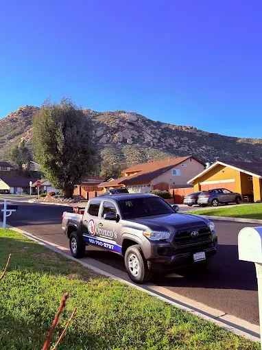 Police pickup truck parked on a suburban street with hills and houses in the background