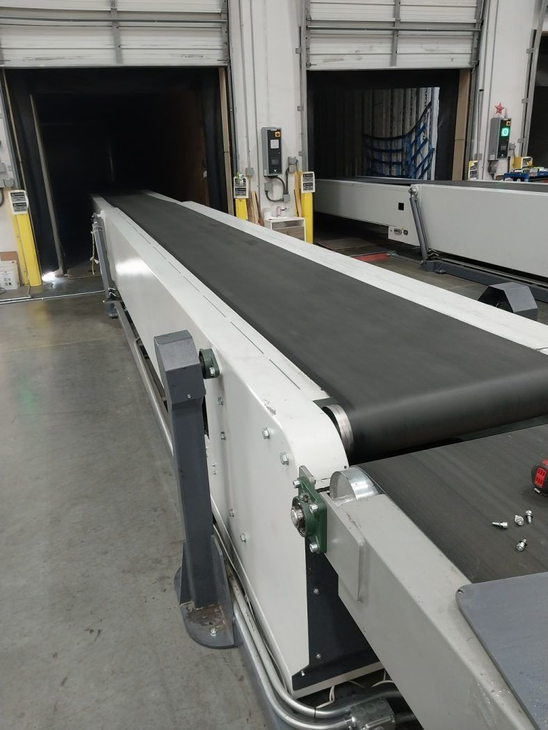 Industrial conveyor belt leading to a loading dock in a warehouse