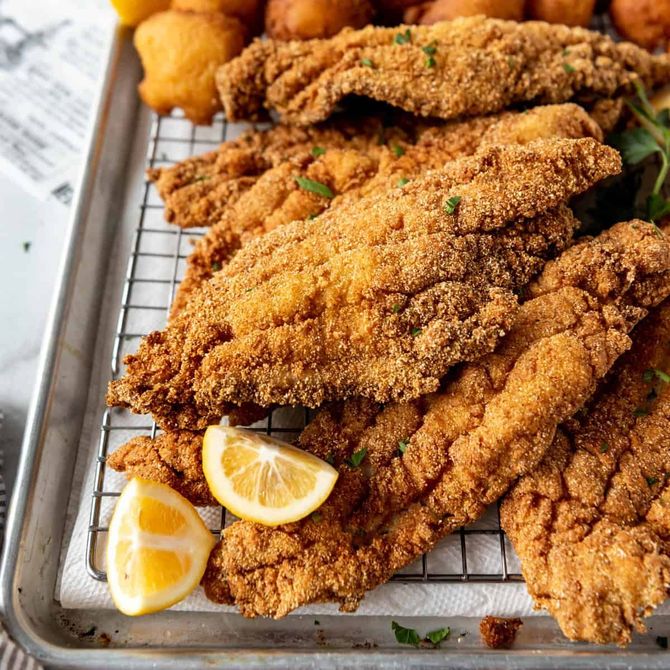 A white plate topped with chicken wings and green onions