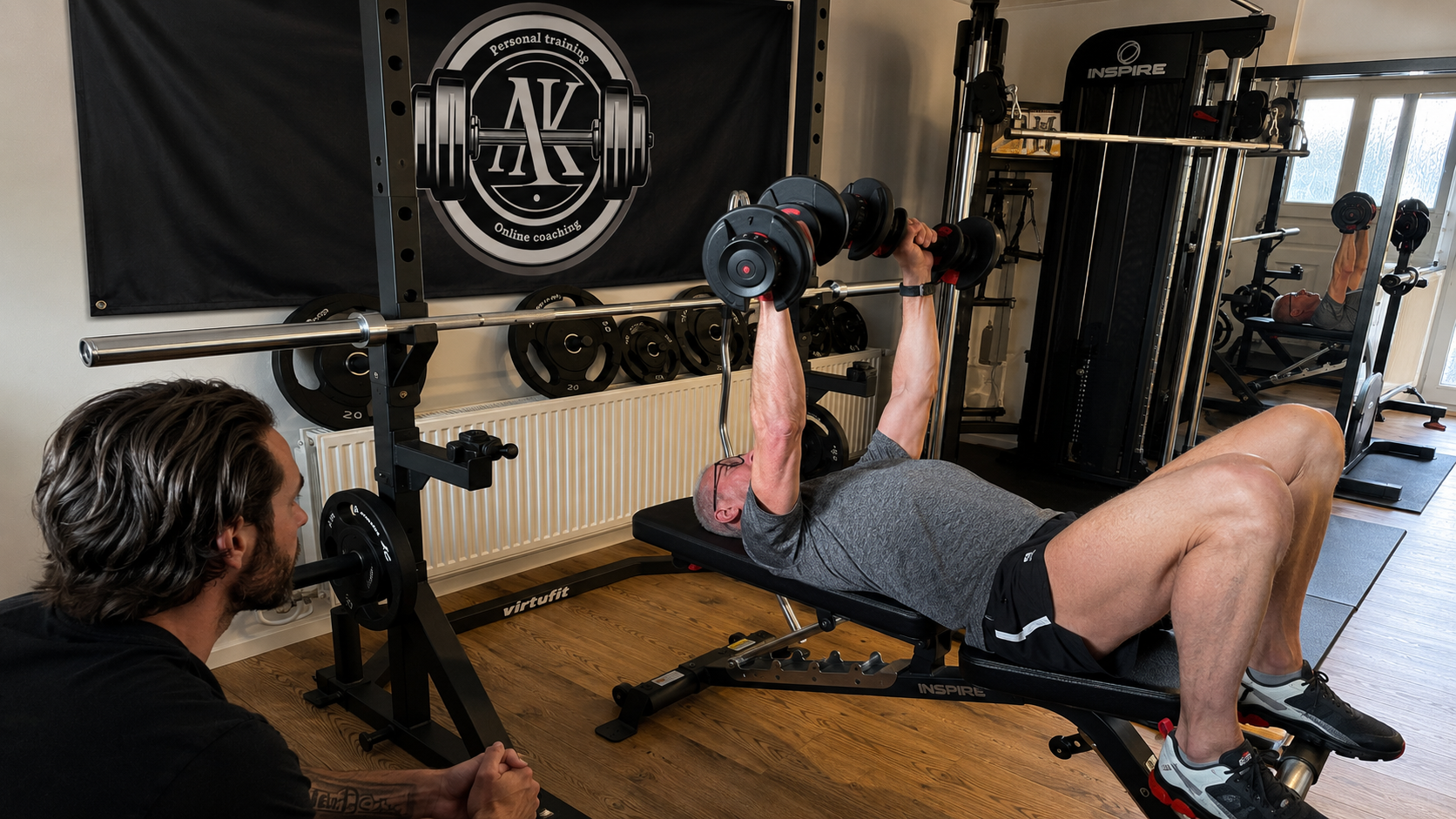 Fitnessruimte voor thuis met gewichtenrek, gewichtsapparaat, gewichten en ringen.