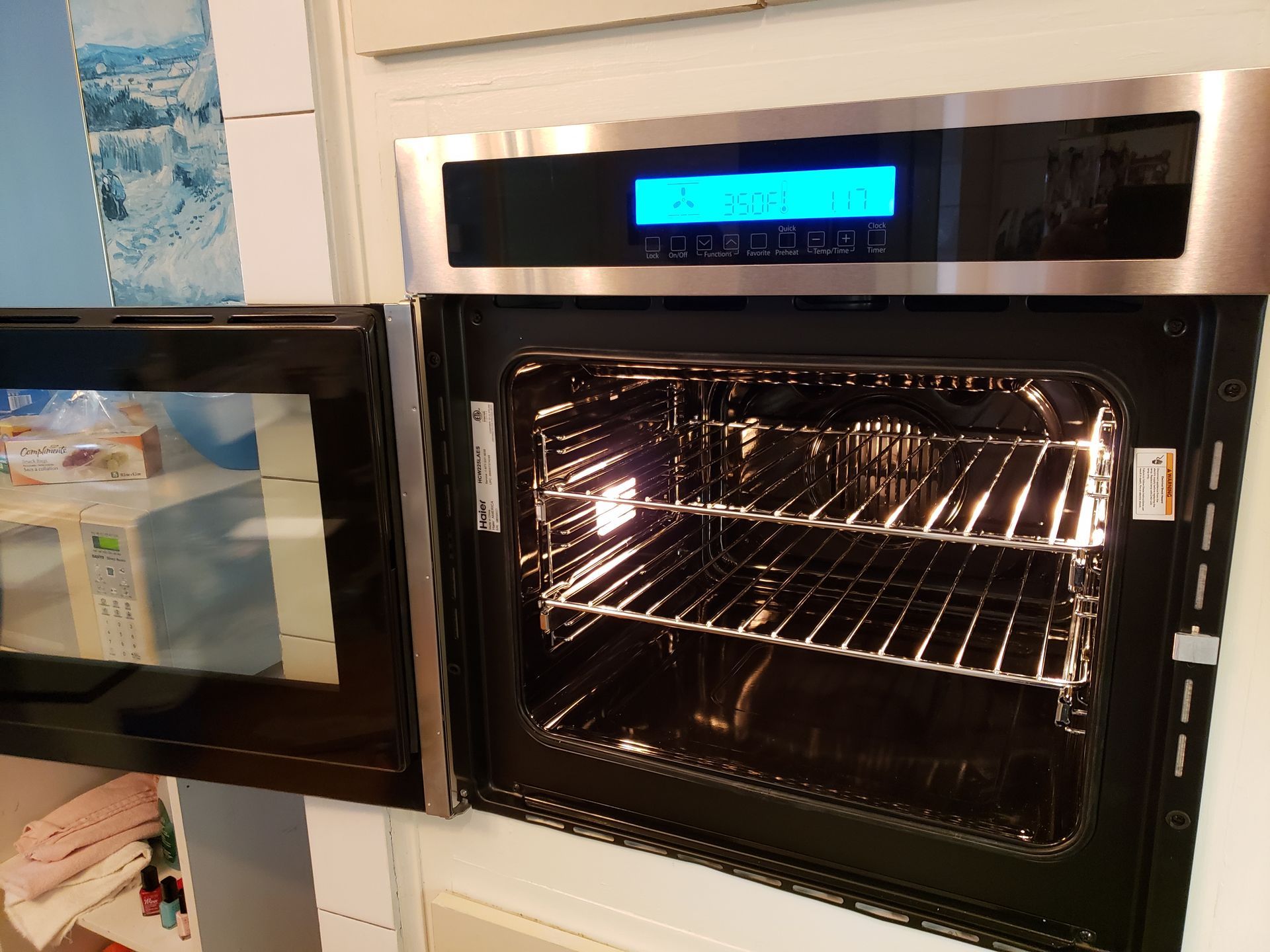 Un four ouvert en acier inoxydable avec deux grilles éclairées de l'intérieur.