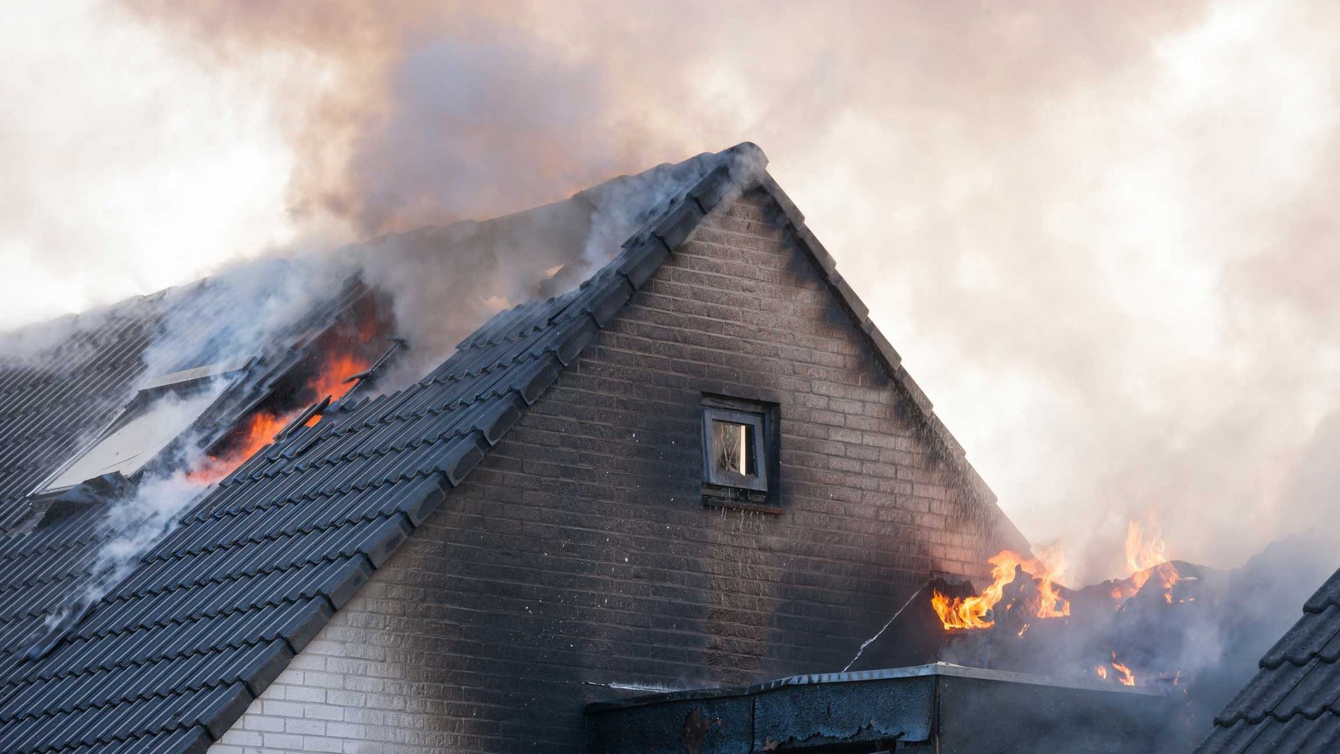Image of A Sooty White Brick Home That Is On Fire With Flames And Smoke Coming Out — Weyauwega, WI