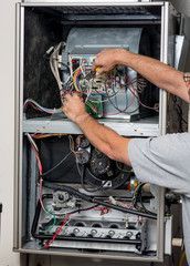 A man is working on a heating system in a house.