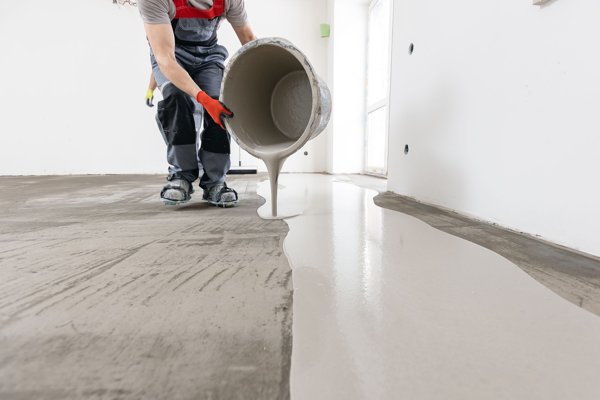 Worker use screed concrete epoxy for level. Leveling with mixture of cement for floors.