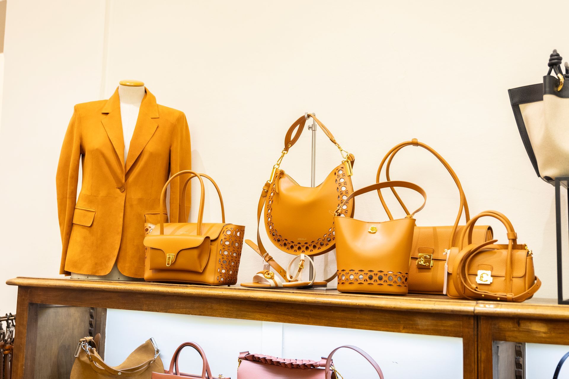 In una boutique, una borsa e un blazer color giallo senape sono esposti su uno scaffale di legno.