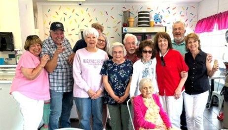 Group of people posing together in a bright decorated room, smiling at the camera.