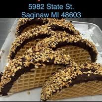 Four chocolate-covered waffle cones topped with nuts in a tray, labeled “5982 State St. Saginaw MI 48603”