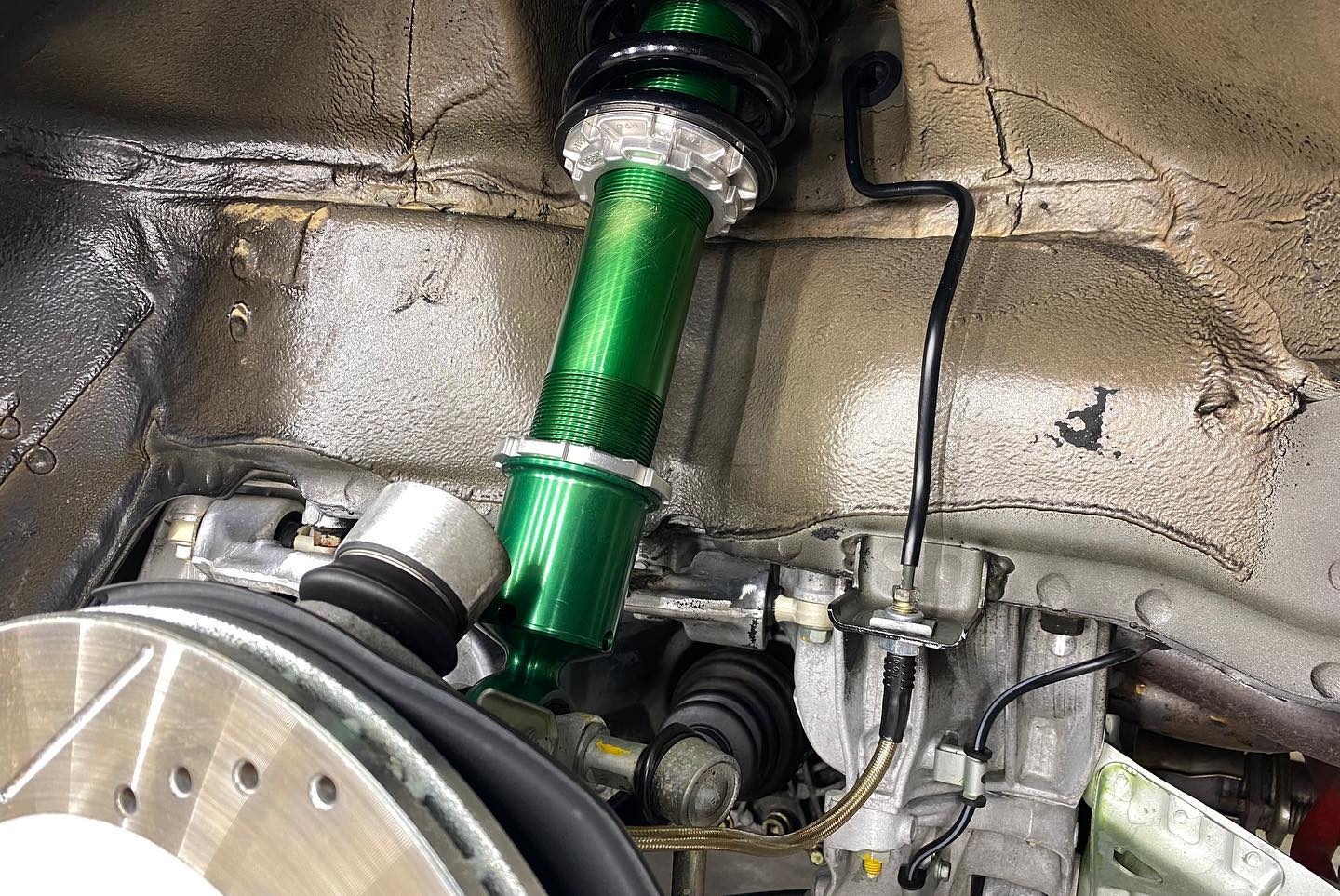 A close up of a green shock absorber on a car.