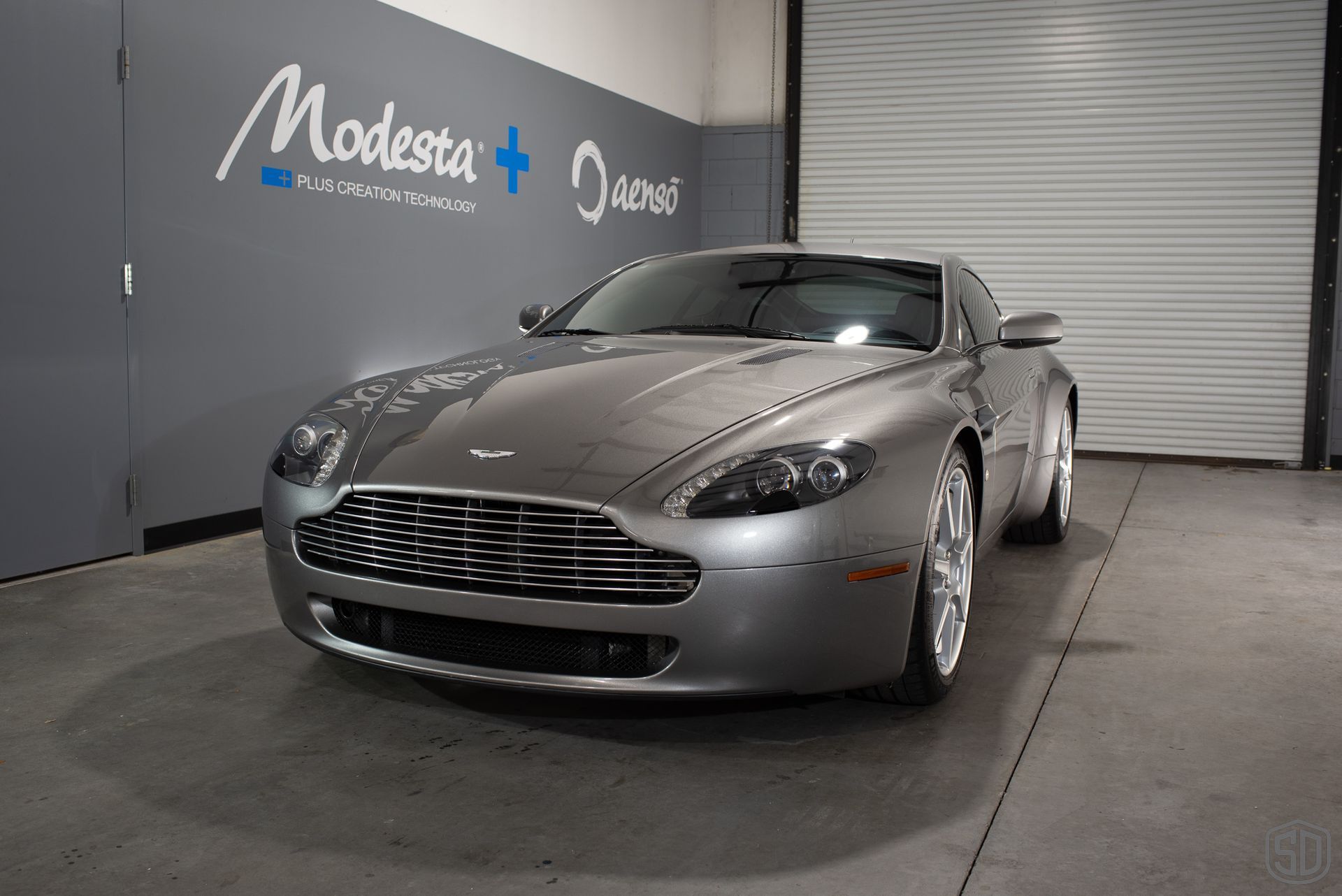 A silver sports car is parked in a garage.