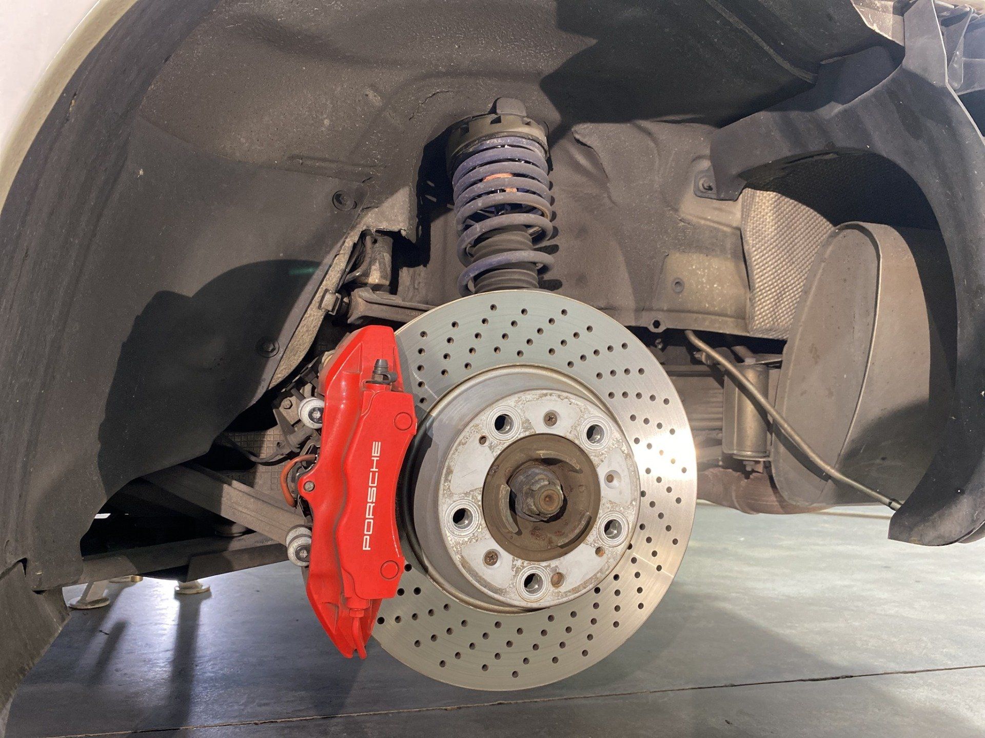 A close up of a porsche car with a red brake caliper