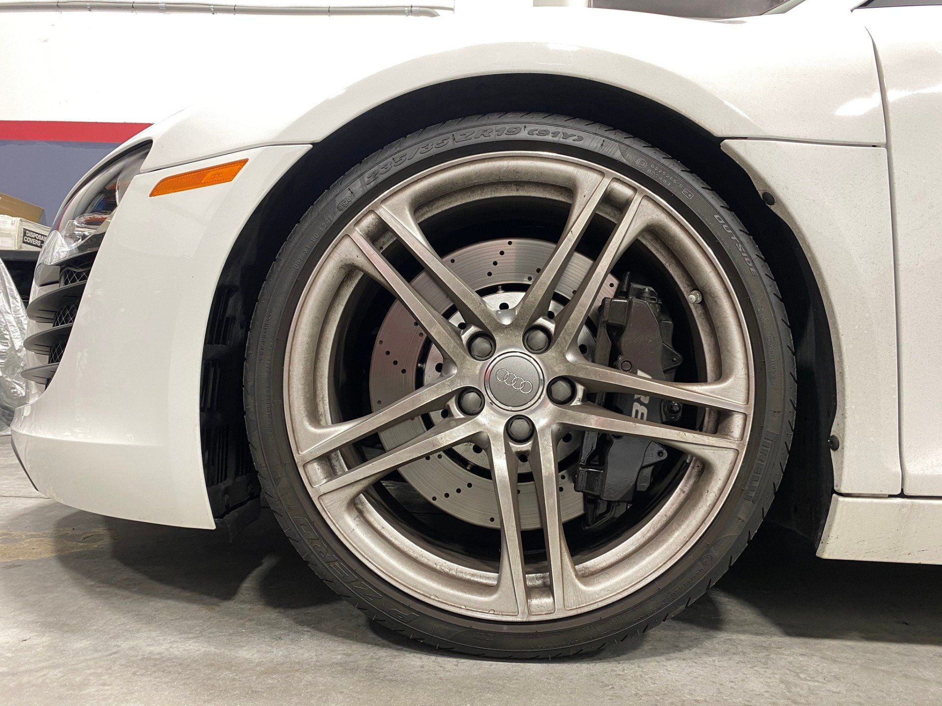 A close up of the front wheel of a white sports car