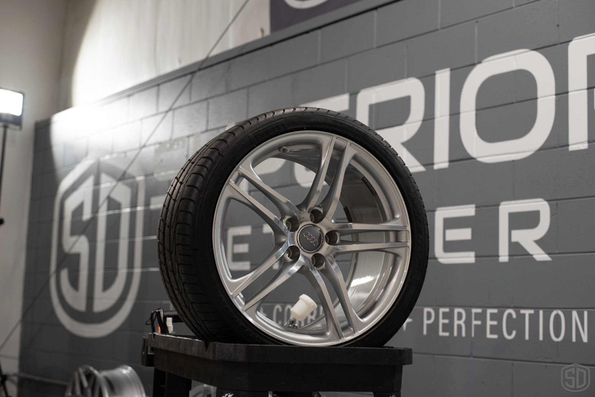 A tire is sitting on a table in front of a sign that says superior perfection