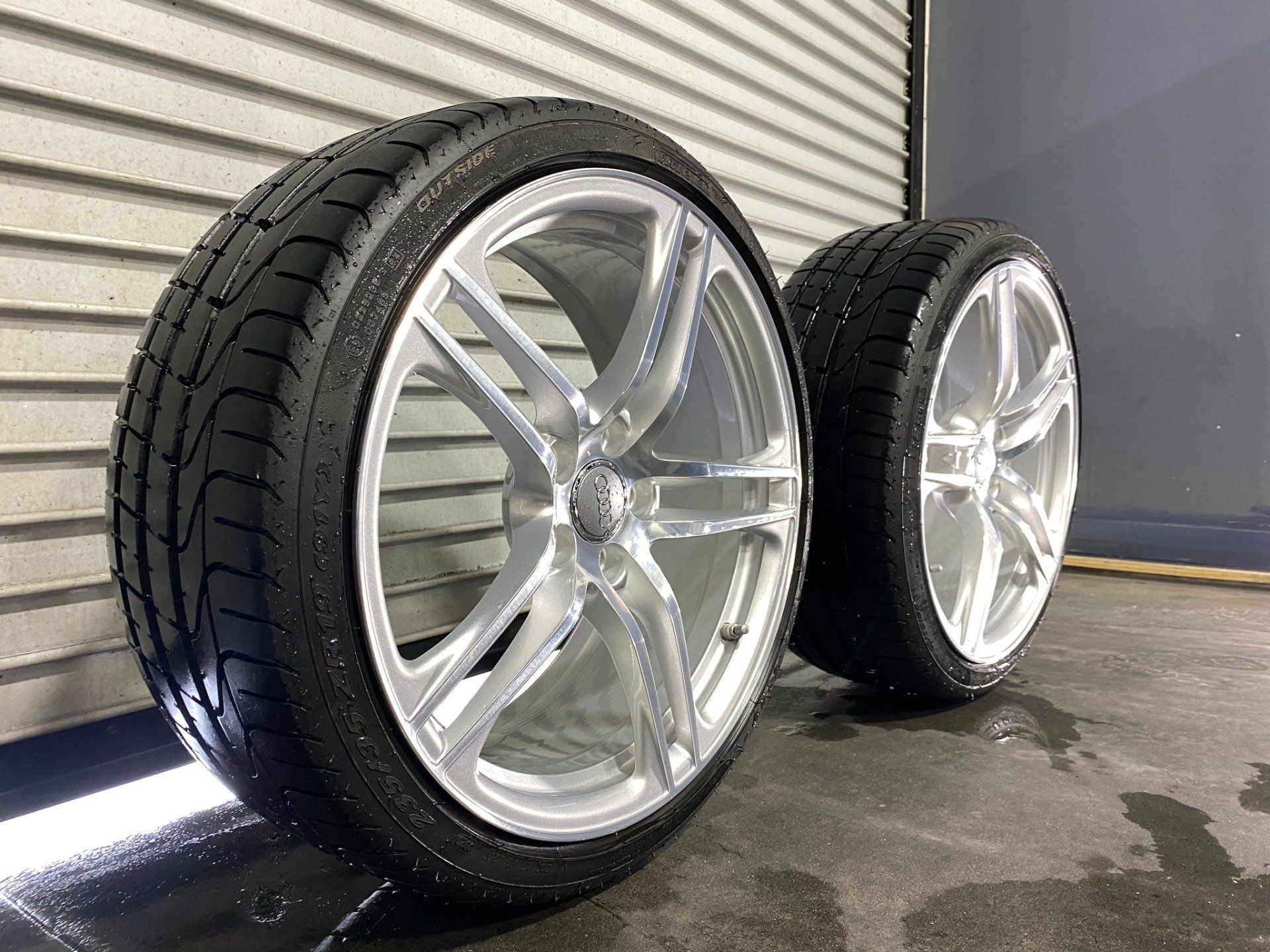 Two tires are sitting next to each other on a concrete floor.